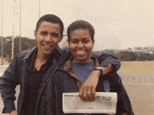 a man and a woman are posing for a picture with the man holding a newspaper