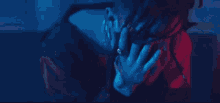 a close up of a person 's face with a red and blue light behind her .
