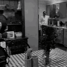 a black and white photo of a kitchen with a table and chairs