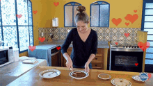 a woman is preparing food in a kitchen with hearts on the wall and the word mundo on the stove