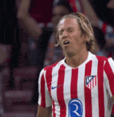 a soccer player wearing a red and white striped shirt with the letter r on it