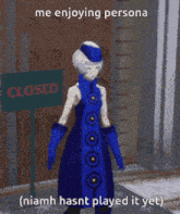 a woman in a blue dress standing in front of a closed sign