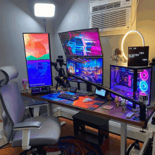 a desk with three monitors and a microphone on it