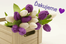 a bouquet of purple and white flowers in a wooden box with the words " dakujeme " above them