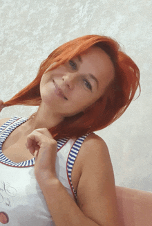 a woman with red hair is wearing a striped tank top that says ' i love you ' on it