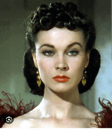 a close up of a woman 's face with a red lip and gold earrings