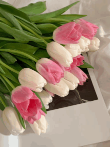 a bunch of pink and white flowers are laying on a magazine