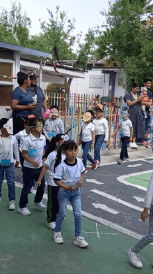 a group of children are walking down a street wearing masks