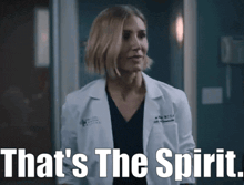 a woman in a lab coat is standing in a room with the words `` that 's the spirit '' written on it .