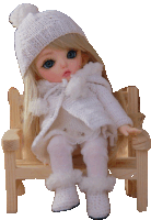 a doll is sitting on a wooden bench wearing a white sweater and hat