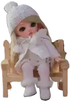 a doll is sitting on a wooden bench wearing a white sweater and hat