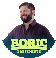 a man with a beard is smiling in front of a boric presidente logo