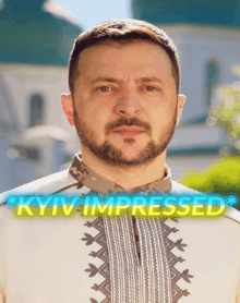 a man with a beard is standing in front of a sign that says ' kyiv impressed '