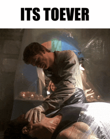 a man is touching another man 's face with the words " it 's toever " below him