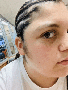 a close up of a woman 's face with a sign in the background that says ' hotel '