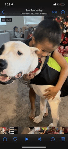 a phone screen shows a picture of a little boy holding a dog in san tan valley