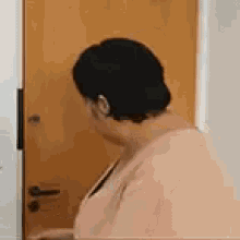 a woman is standing in front of a door and looking at it .