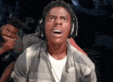 a young man wearing headphones is making a surprised face