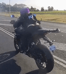 a person riding a motorcycle with a license plate that says 467 zn