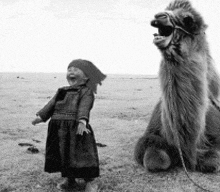 a little girl is standing next to a large camel