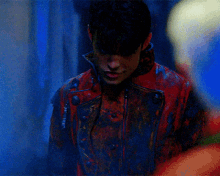 a man in a red jacket is standing in a blue room