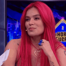 a woman with red hair is standing in front of a screen that says hor uef