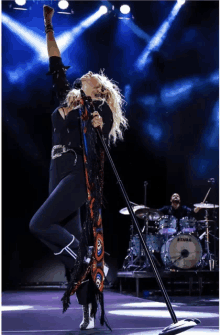 a woman singing in front of a drum set that says tama