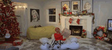 a woman in a red sweater sits on a stuffed polar bear in front of a fireplace