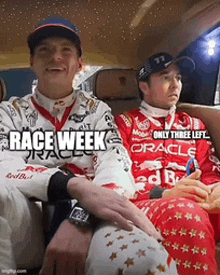 two race car drivers are sitting in the back seat of a car and one of them is wearing a shirt that says race week