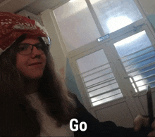 a man with long hair wearing glasses and a bandana with the word go on it