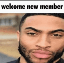 a man with a beard is making a funny face with the words `` welcome new member '' behind him .