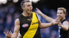 a man in a yellow and black jeep jersey celebrates a goal