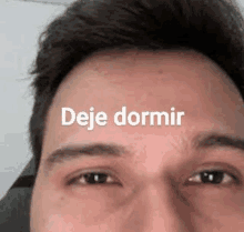 a close up of a man 's face with the words `` deja dormir '' written on it .