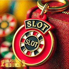 a red and gold keychain that says slot on it