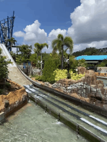 a water slide at a water park with a blue building behind it