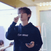 a young man wearing a black hoodie that says covernat on it