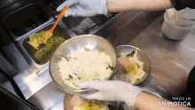 a person is preparing food in a metal bowl with a spoon and the words made in animotica on the bottom