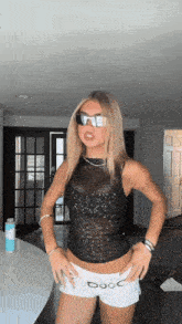 a woman wearing a black top and white shorts with the word coco on the bottom