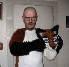 a man in a furry fox costume is holding a stuffed animal