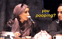 a woman with purple hair is speaking into a microphone with the words " you pooping " written above her