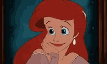 a cartoon of ariel from the little mermaid is smiling and looking at the camera .