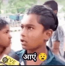 a young boy is talking into a microphone and making a funny face in a foreign language .