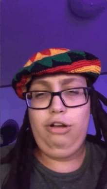 a woman wearing glasses and a rasta hat