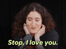 a woman with curly hair says " stop i love you " in front of a microphone