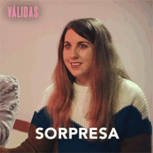 a woman in a sweater is smiling and the word sorpresa is on the bottom