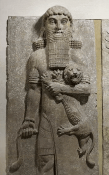 a statue of a bearded man holding a lion .