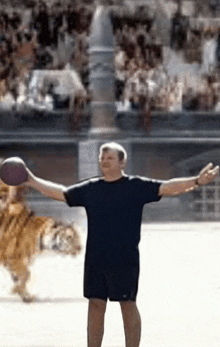 a man with his arms outstretched is standing in front of a tiger