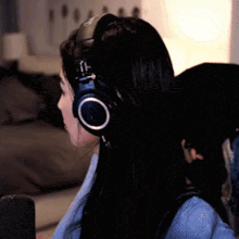 a woman wearing headphones is sitting on a couch .