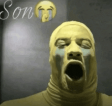 a man in a yellow mask is crying with the word son written on the bottom