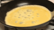 an omelet is being cooked in a frying pan on a stove top